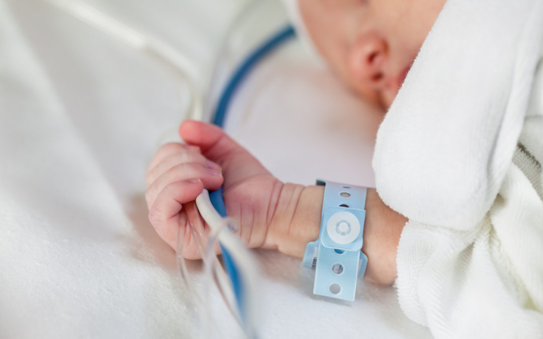 Newborn baby holding cables